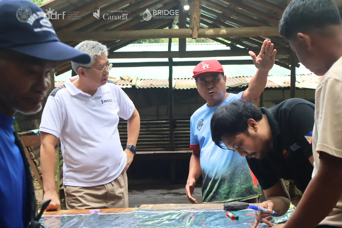 Community members and facilitators work together around a printed map.